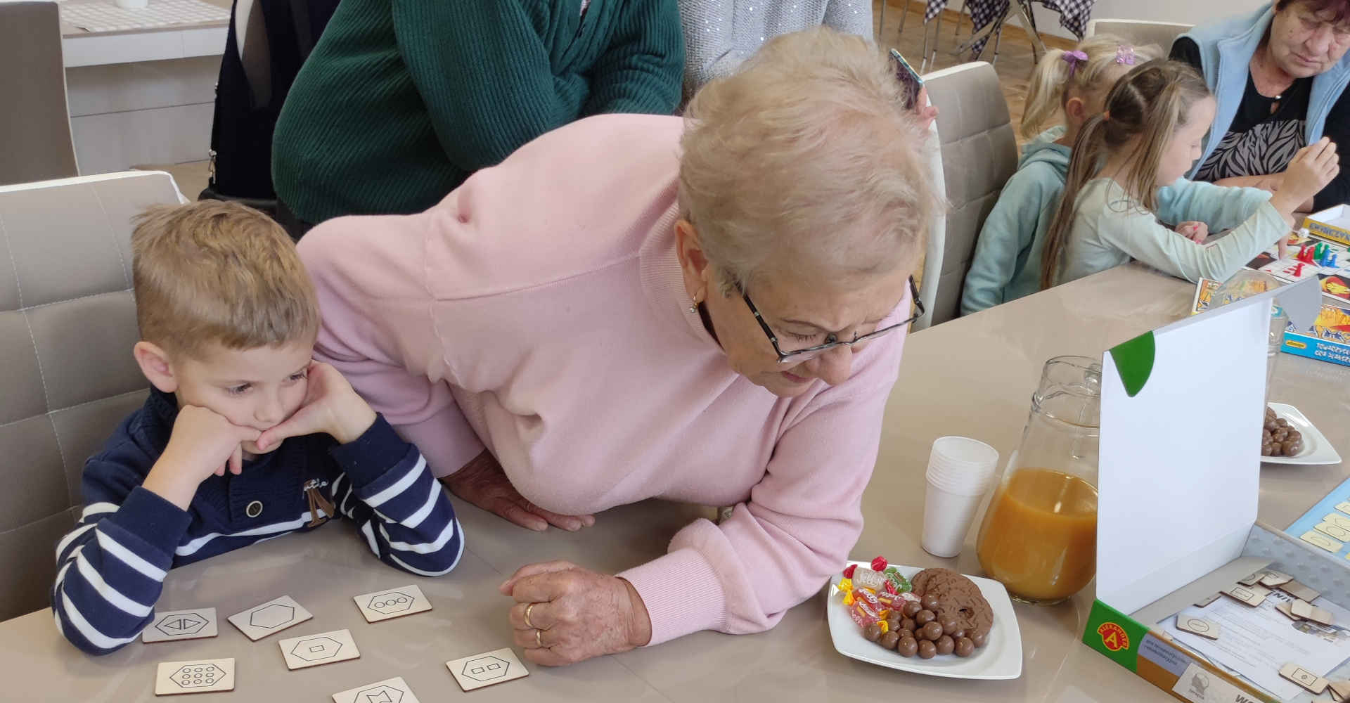 Chłopiec z seniorką podczas gry planszowej