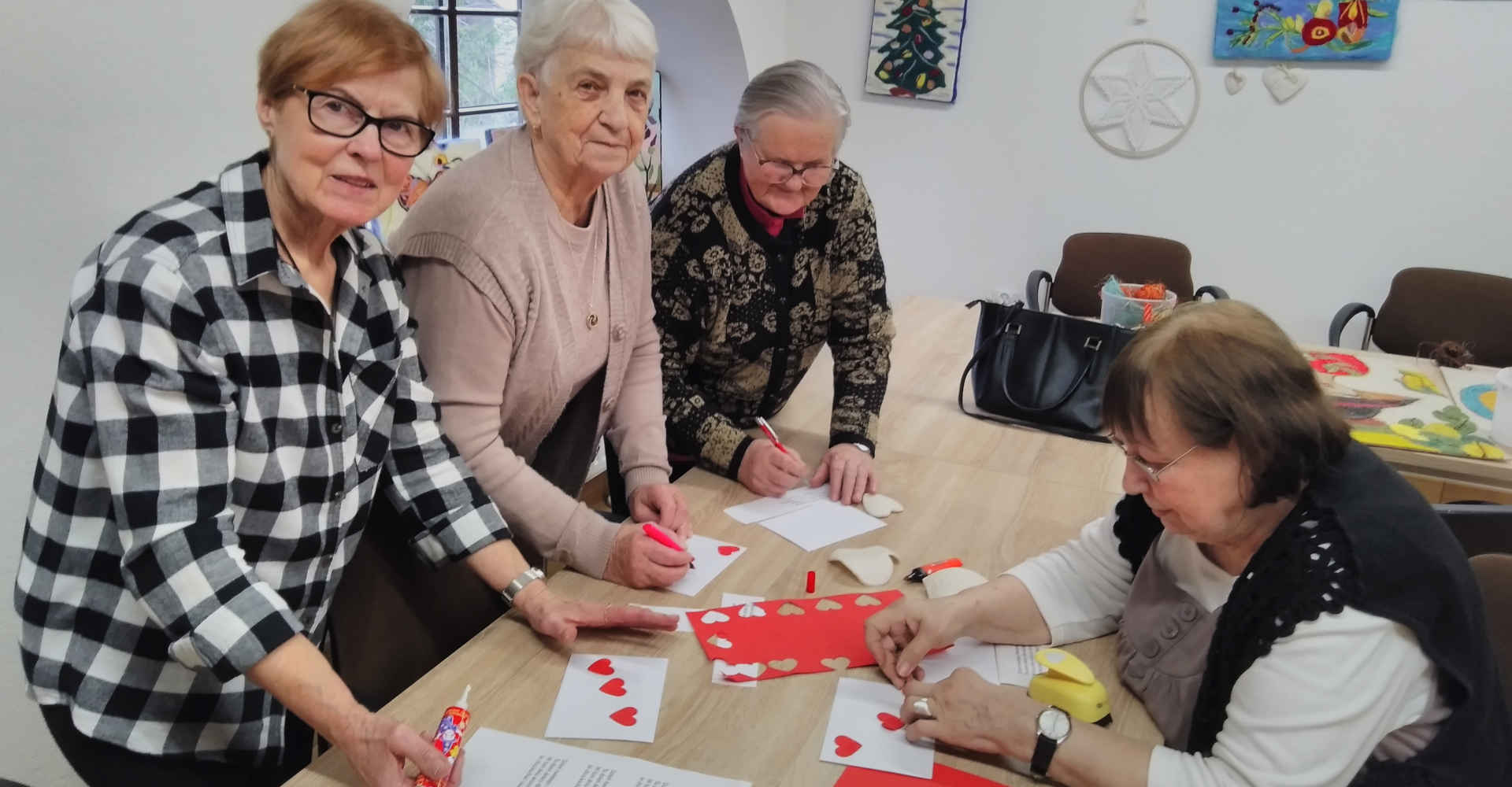 Seniorzy podczas wykonywania czerwonych serduszek